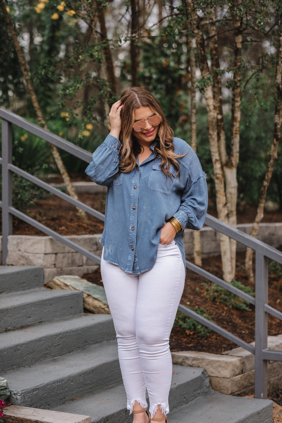 loose long-sleeve top made of soft lightweight material with a button up front, a collared neckline, button closure cuffs, two oversized accent chest pockets, and a slouched silhouette that falls into a rounded hemline with an oversized fit on an acid-washed colored fabric in chambray