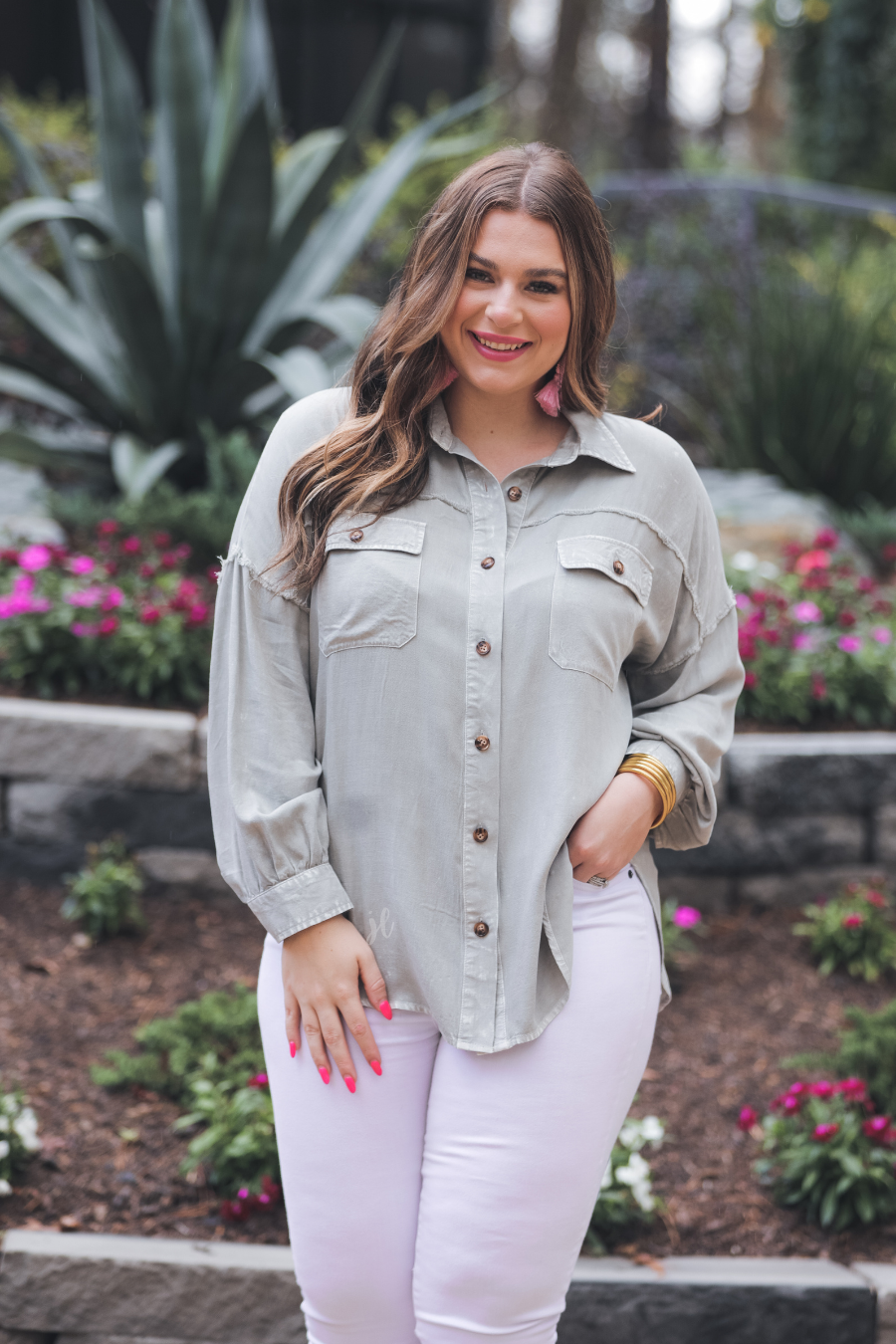 loose long-sleeve top made of soft lightweight material with a button up front, a collared neckline, button closure cuffs, two oversized accent chest pockets, and a slouched silhouette that falls into a rounded hemline with an oversized fit on an acid-washed colored fabric in grey