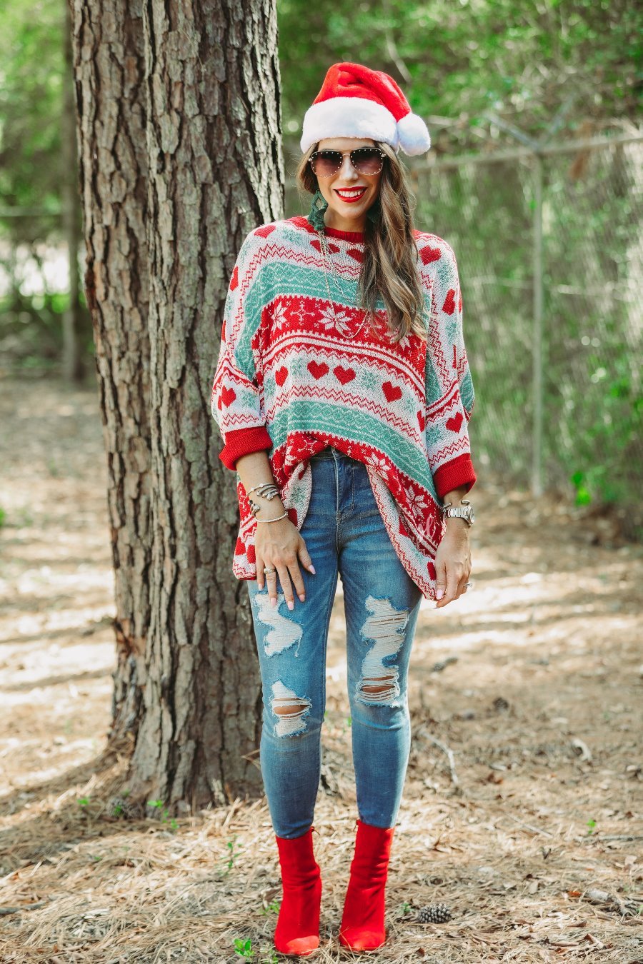 three-quarter cuffed sleeve unlined sweater crafted from a lose knit material with an oversized fit, a rounded neckline, a chest pocket, and red trim on the collar, hem, and pocket on a seasonal pattern (geometric designs, hearts, and snowflakes)