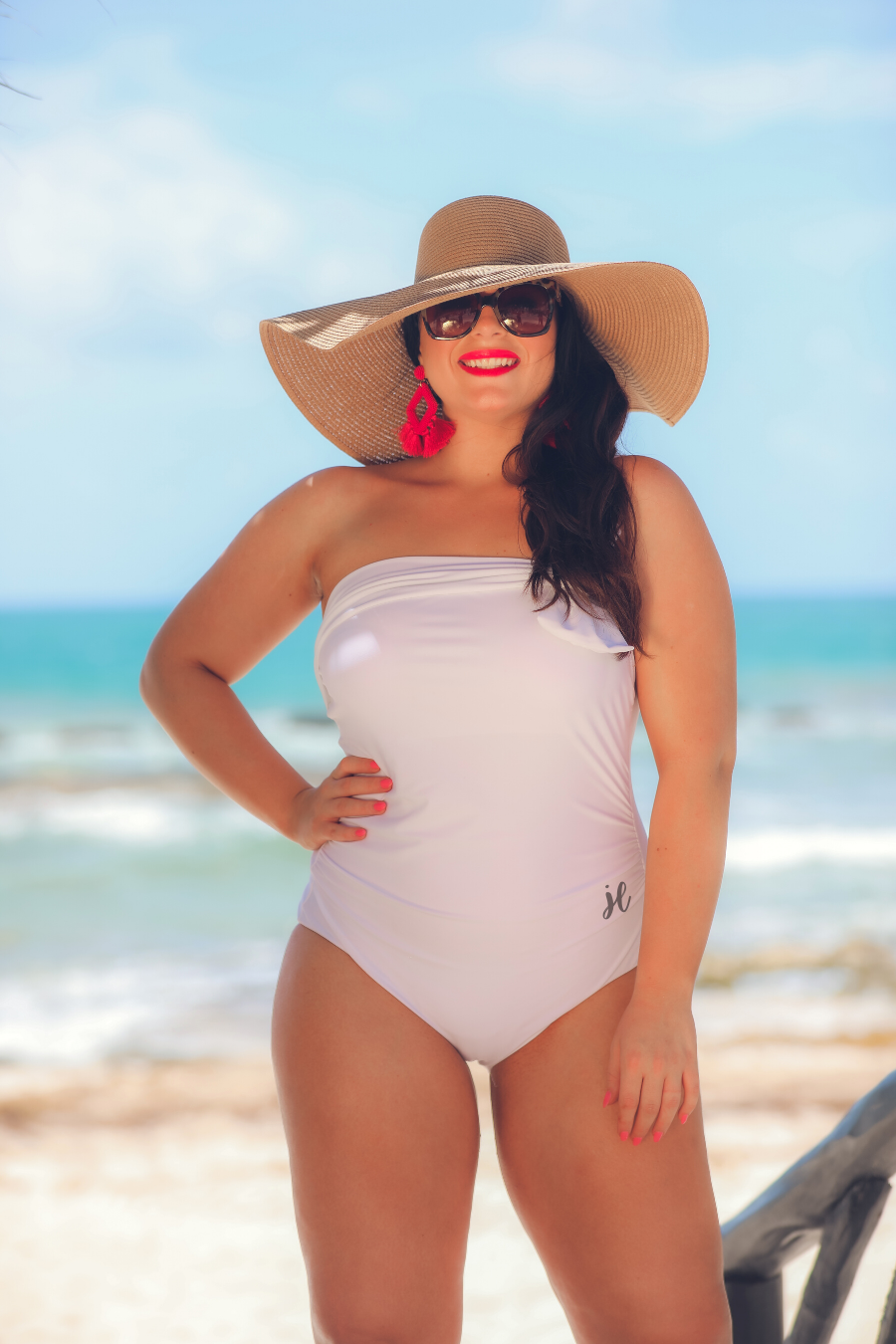 white one-piece swimsuit made of lightweight stretchy material with a one-shoulder neckline, a white matching bow, an adjustable strap, and a padded bust