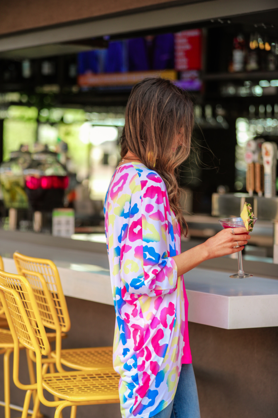 three-quarter sleeve open front cardigan made of lightweight material that drapes into a cocoon shape on a vibrant leopard print pattern fabric in white