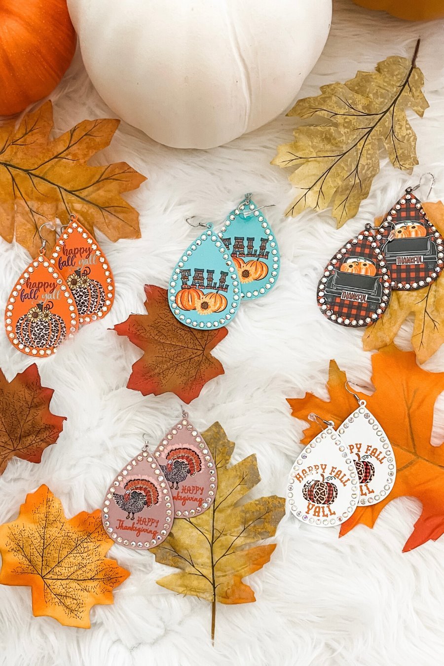 lightweight, seasonal-inspired leopard-theme teardrop-shaped earrings outlined in rhinestones with a fish hook in mauve leopard pumpkin, orange leopard pumpkin, plaid pumpkin truck, teal pumpkin, and white leopard pumpkin