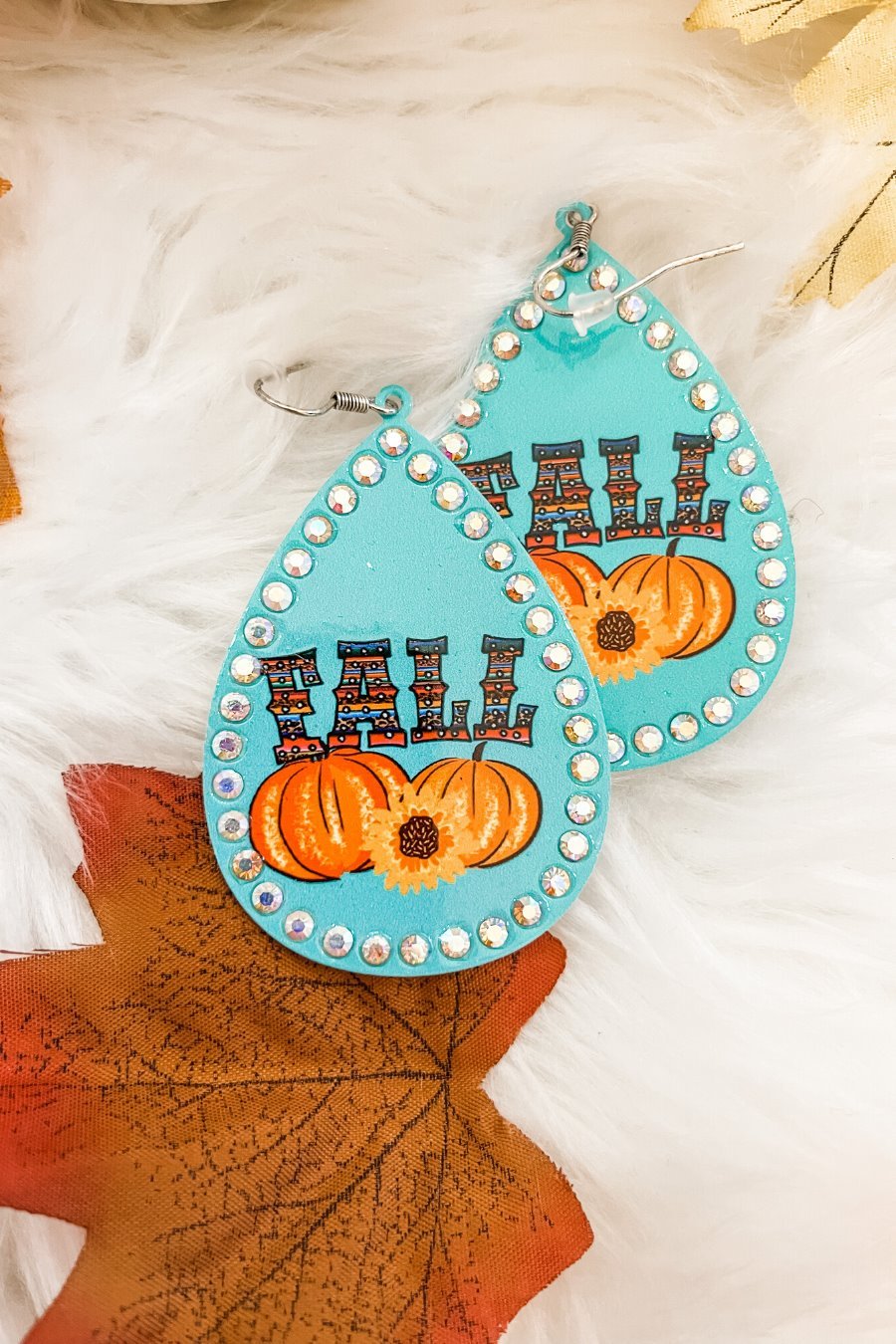 lightweight, seasonal-inspired leopard-theme teardrop-shaped earrings outlined in rhinestones with a fish hook in teal serape pumpkin