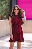 ruffled sleeve dress with layered pleats, an elastic waistband, and a lined bottom in burgundy