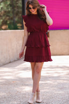 ruffled sleeve dress with layered pleats, an elastic waistband, and a lined bottom in burgundy