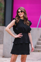 ruffled sleeve dress with layered pleats, an elastic waistband, and a lined bottom in black
