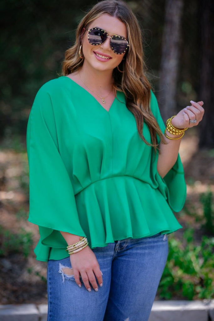 dolman long sleeves top with a plunging v-neckline and a gathered waistline in green