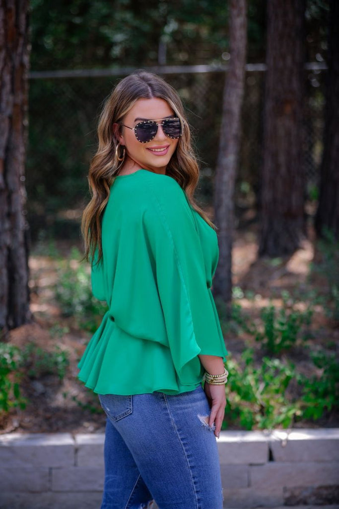 dolman long sleeves top with a plunging v-neckline and a gathered waistline in green