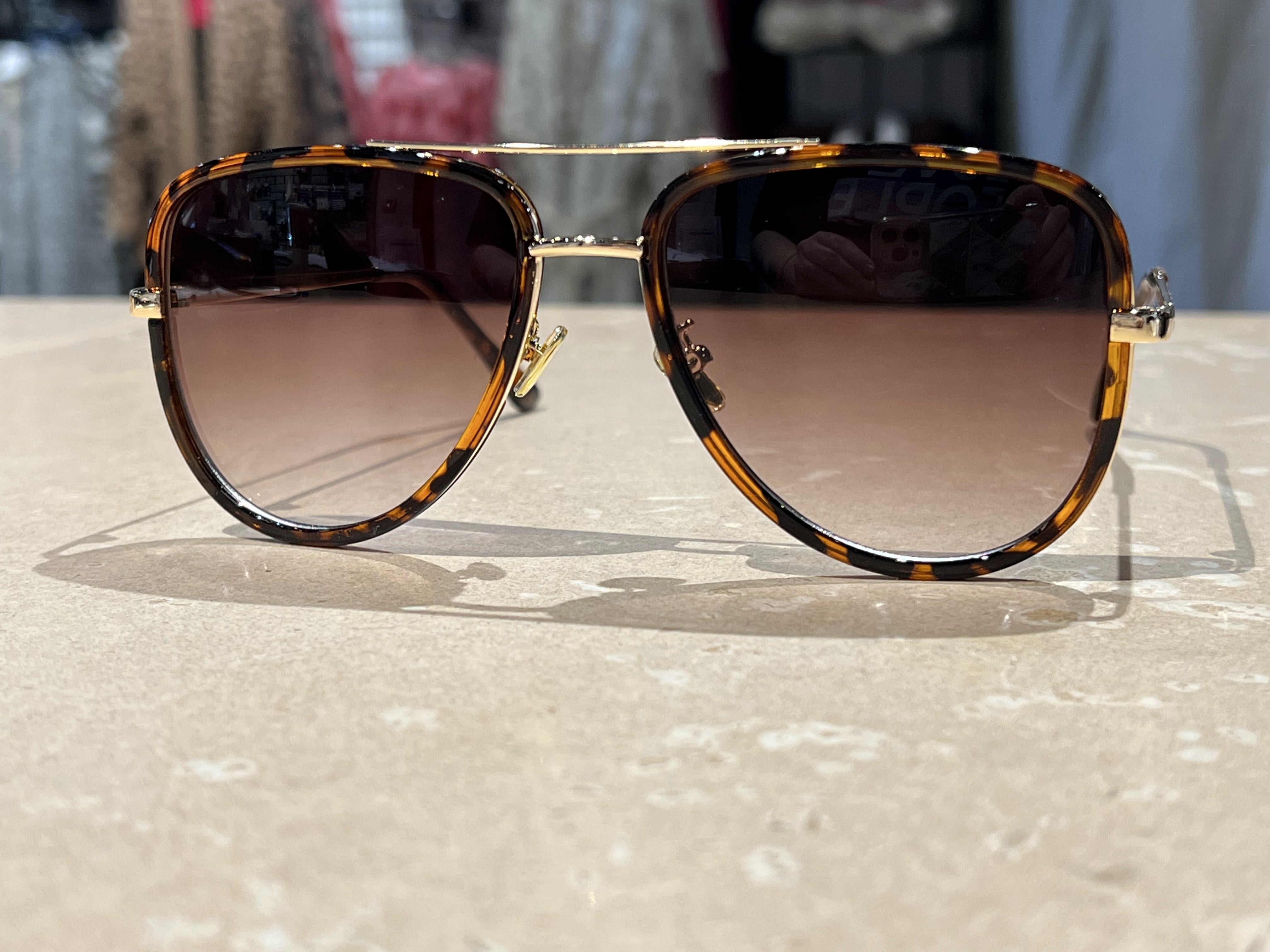 brown aviator sunglasses with thin round wireframes, tinted lenses, UV protection, and brand name detail (on both the temple and the complimentary black pouch)