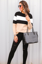long-sleeve sweater crafted from a soft mid weight knit with bold horizontal blocks of black, tan, and white