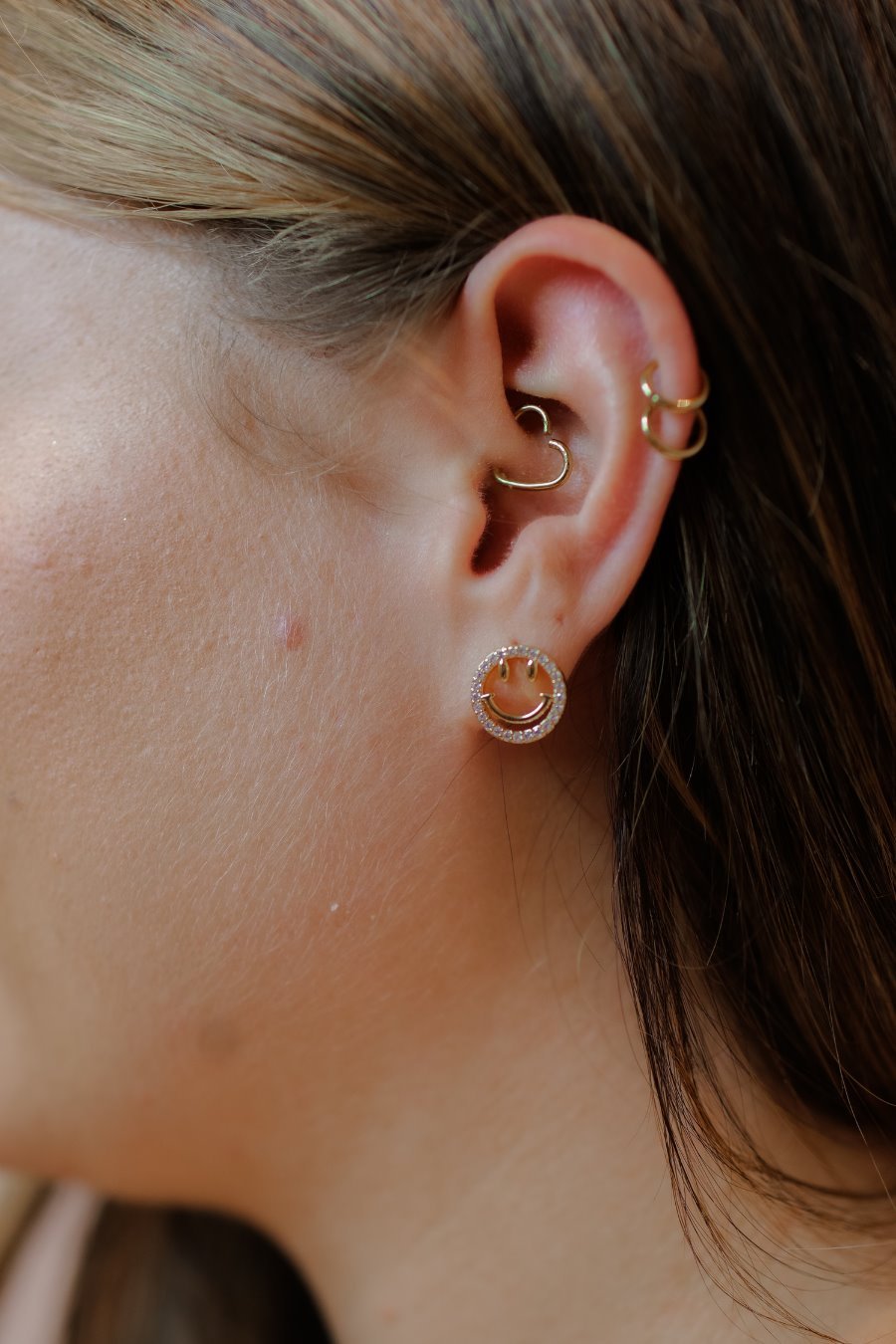 stud earrings in the shape of a gold happy face surrounded by sparkling rhinestones