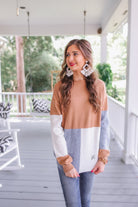 long-sleeve sweater with a rolled collar and a tri-colorblock of heather gray, ivory, and mocha