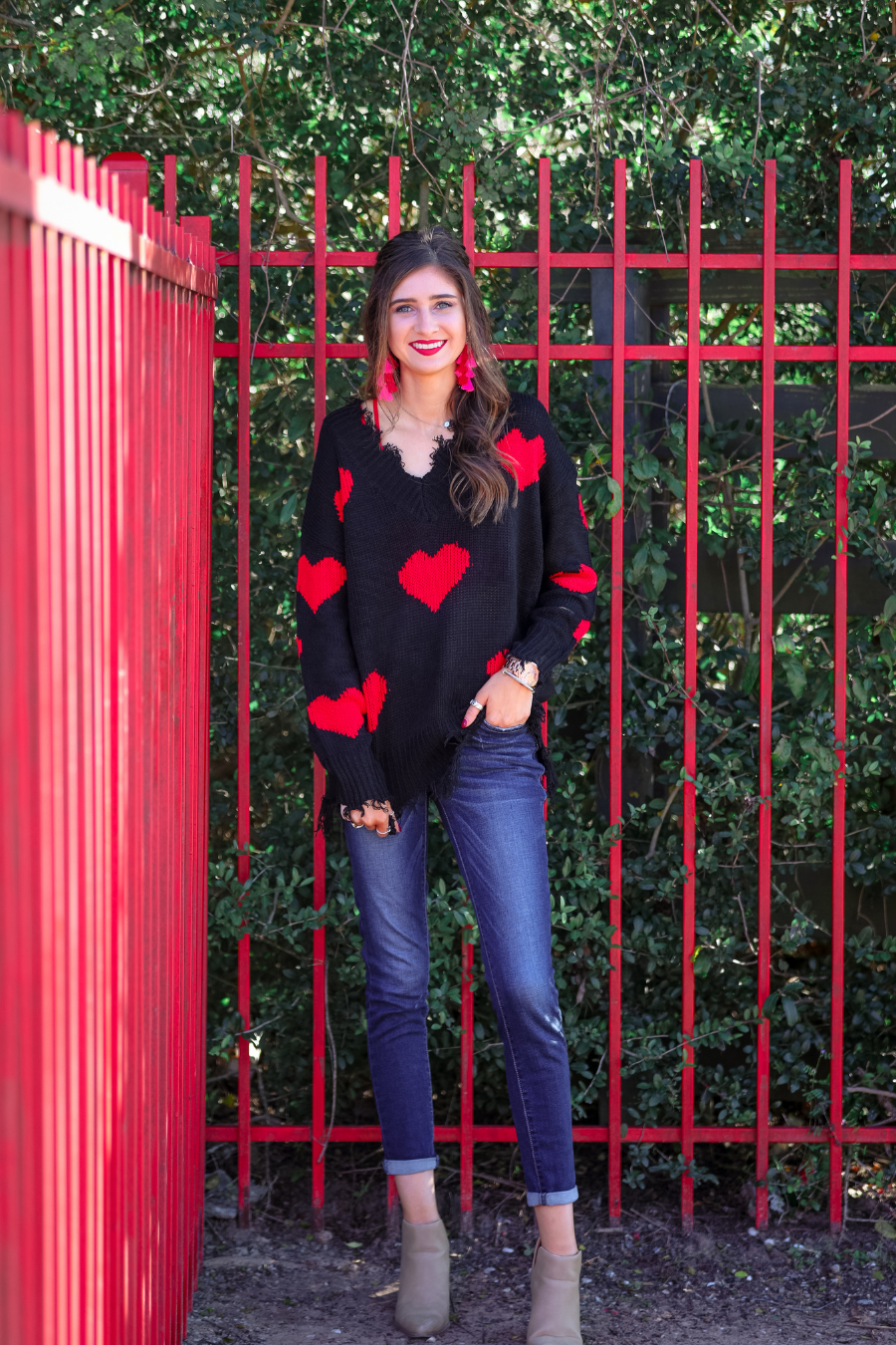 long sleeve sweater made of super soft, stretchy knit fabric with a distressed v-neck and trim on a red heart pattern