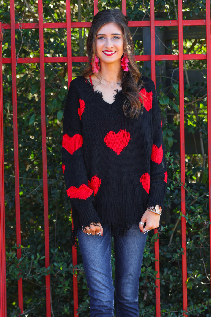 long sleeve sweater made of super soft, stretchy knit fabric with a distressed v-neck and trim on a red heart pattern