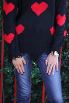 long sleeve sweater made of super soft, stretchy knit fabric with a distressed v-neck and trim on a red heart pattern