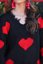 long sleeve sweater made of super soft, stretchy knit fabric with a distressed v-neck and trim on a red heart pattern