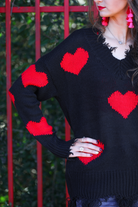 long sleeve sweater made of super soft, stretchy knit fabric with a distressed v-neck and trim on a red heart pattern