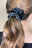 a classic pleather scrunchie paired with bold animal print and elastic in black