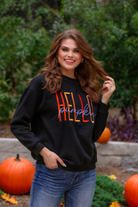 long sleeves black sweatshirt with colorful HELLO embroidered under white cursive PUMPKIN