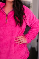 long-sleeve plush fleece pullover with quarter zip, front pockets, and a foldable collar on a super soft hot pink fabric