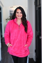 long-sleeve plush fleece pullover with quarter zip, front pockets, and a foldable collar on a super soft hot pink fabric