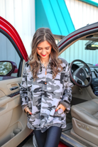 a long-sleeve luxurious faux fur material with a quarter zip, front pockets, and a foldable collar on a camouflage pattern fabric