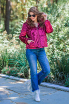 long-sleeve zip front closure jacket with a collar, side pockets, and adjustable drawstring hems made of lightweight material in wine color