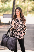 a long-sleeve fluffy pullover with a quarter zip, convenient front pockets, a foldable collar, and an elastic band at the hemline one a pink leopard sherpa fabric