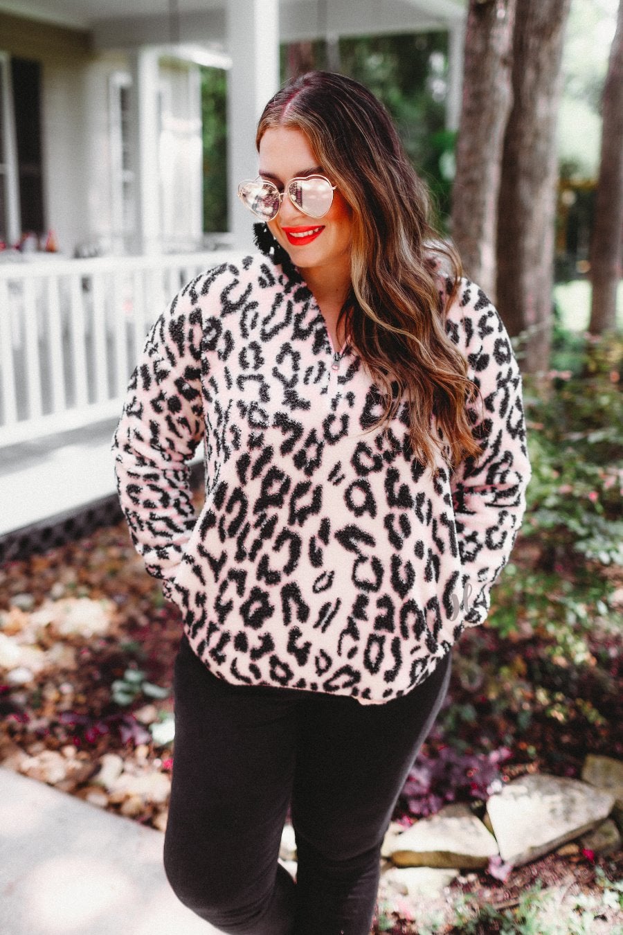 a long-sleeve fluffy pullover with a quarter zip, convenient front pockets, a foldable collar, and an elastic band at the hemline one a pink leopard sherpa fabric