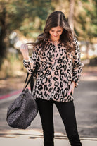 a long-sleeve fluffy pullover with a quarter zip, convenient front pockets, a foldable collar, and an elastic band at the hemline one a pink leopard sherpa fabric