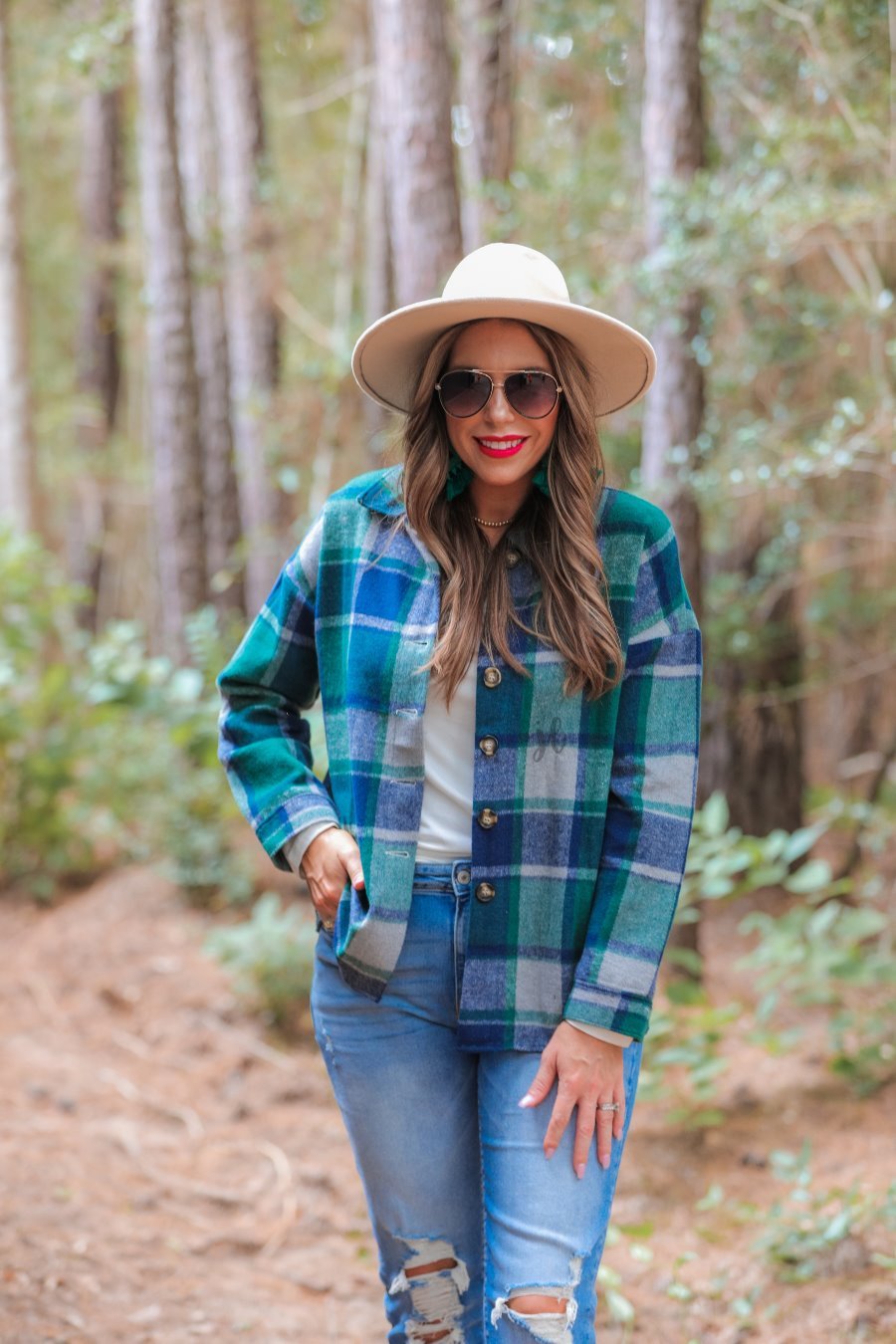 long-sleeves with fitted button closure cuffs, a button-down front, and a collared neckline on a green plaid print