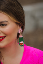 a flower stud adorned with gold, green, orange, and pink beads in the shape of a rosé bottle