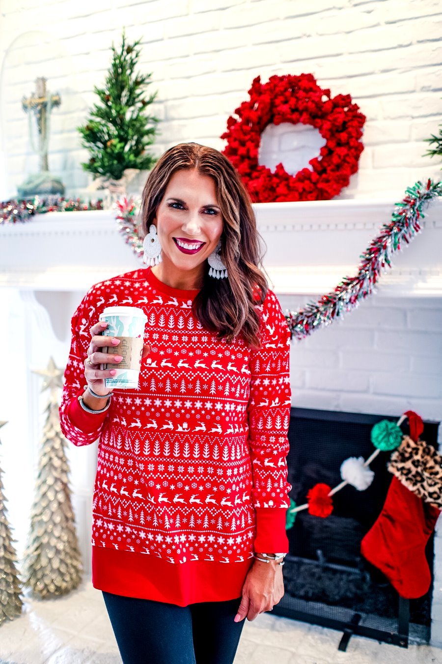 a red long-sleeve tunic made from comfy material with comfy material with a sublimation-printed Christmas pattern print (geometric designs, reindeer, Santa's sleigh, snowflakes, and trees) sublimation detail, ribbed accents (cuffs, neckline, and hem), side slits, and a relaxed fit
