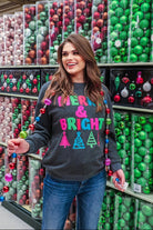 a charcoal long-sleeve sweatshirt with a fuzzy inside, sewn on color chenille letters, and Christmas tree patches