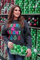 a charcoal long-sleeve sweatshirt with a fuzzy inside, sewn on color chenille letters, and Christmas tree patches