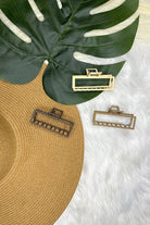 a metal neutral rectangular claw clip with a secure hold that reduces breakage in brown, peach, and tan