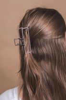 a metal neutral rectangular claw clip with a secure hold that reduces breakage in brown