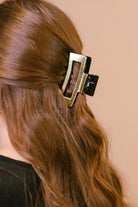 a metallic claw clip with a strong hold and sleek shine in gold