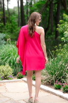 a magenta one-shoulder mini dress with an asymmetrical neckline and a draping, billowy body creating a relaxed silhouette 