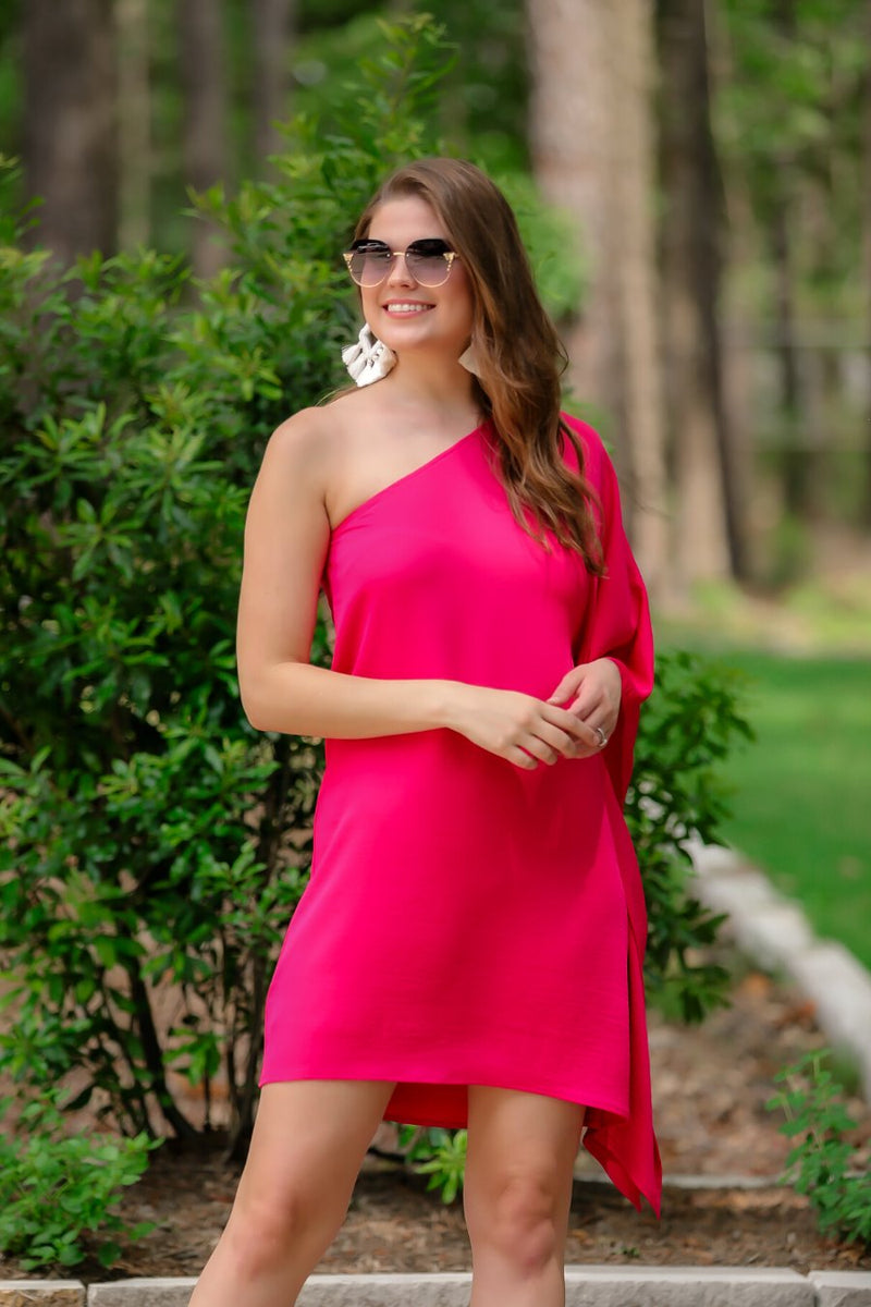 a magenta one-shoulder mini dress with an asymmetrical neckline and a draping, billowy body creating a relaxed silhouette 