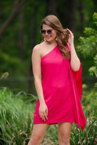 a magenta one-shoulder mini dress with an asymmetrical neckline and a draping, billowy body creating a relaxed silhouette 