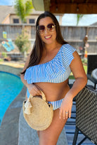 two-piece swimsuit with a ruffle bikini crop top and a full coverage high-waisted bottom on a blue and white striped pattern