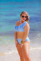 two-piece swimsuit with a ruffle bikini crop top and a full coverage high-waisted bottom on a blue and white striped pattern