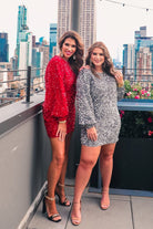 a long balloon sleeve dress made of sparkly allover sequins, luxe velvet underlay, a keyhole accented upper back with button closure, a round neckline, and subtle elastic cuffs in red and silver