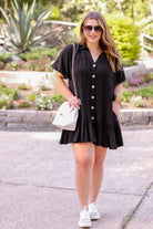 button-up front, a collared v-cut neckline, loose half sleeves, side pockets, and a tiered ruffled hemline