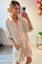 button-up front, a collared v-cut neckline, loose half sleeves, side pockets, and a tiered ruffled hemline