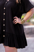 button-up front, a collared v-cut neckline, loose half sleeves, side pockets, and a tiered ruffled hemline