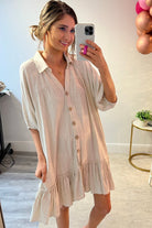 button-up front, a collared v-cut neckline, loose half sleeves, side pockets, and a tiered ruffled hemline