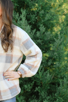 a taupe long-sleeve pullover with a neutral plaid pattern, a quarter zip, a foldable collar, and pockets made of a super soft material