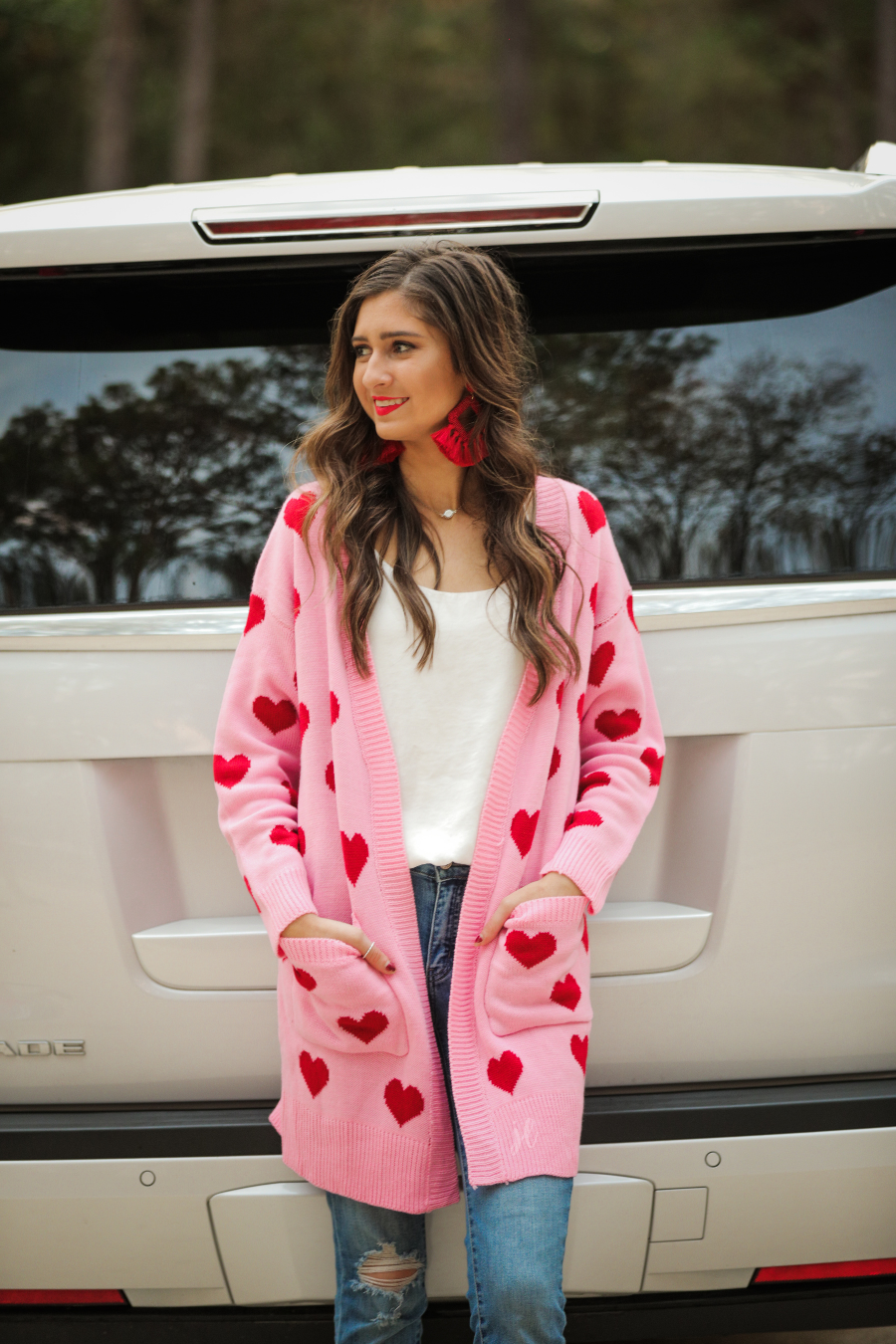 pink long sleeve open-front cardigan with pockets on a red heart pattern fabric